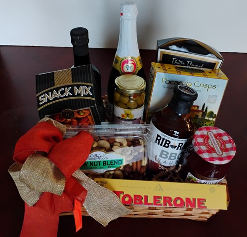 A gift basket filled with BBQ Sauce, nuts, Olive Cooking Oil, crackers, and snacks for delivery in Boston, MA.