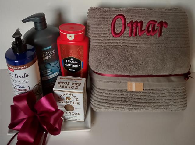 Gift set with personalized bath towel for men. On a white surface Available at KJ Paula Gift in Boston Mass.
