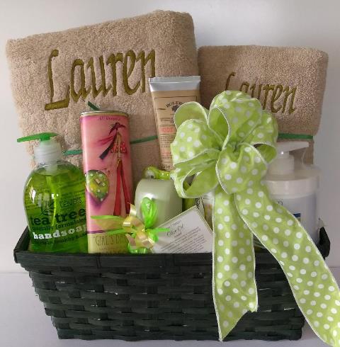 A wicker basket filled with personalized towels and bath and body gift item