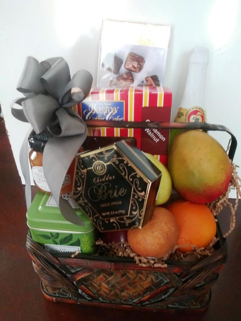 A Boston Coffee Cake Gift Basket, chocolate, tea, cracker, and fruit packed in gift basket