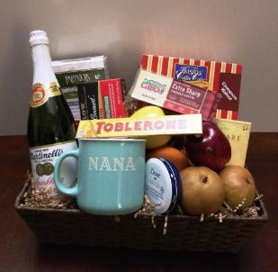 A gift basket packed with a Mug, coffee cake, fresh fruits, cheese, and snacks at KJ Paula Gift Baskets for delivery in Boston.