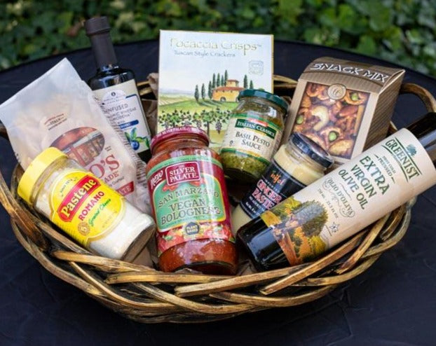 A housewarming gift basket, with pesto sauce, pasta, pasta sauce, olive oil, and parmesan cheese is available at KJ Paula Boston, MA.