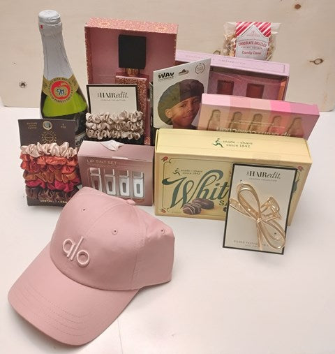 Gift with personal touch for female birthday celebration. Gift are display an a clear surface, chocolates and girly gift items. 