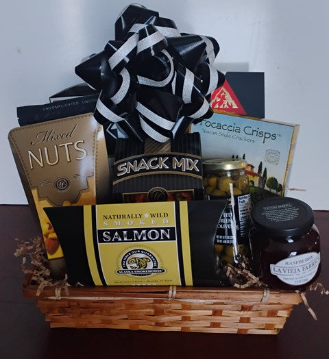a basket filled with smoked salmon, mixed nuts, snack mix, and gourmet snacks