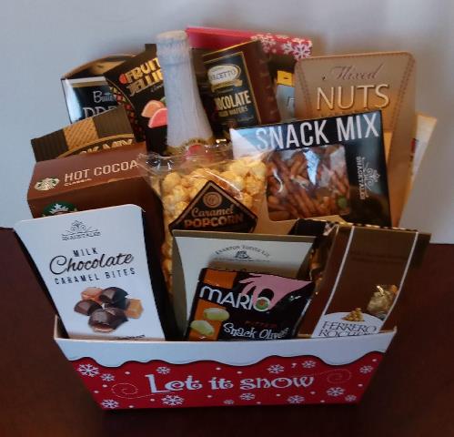 An ideal Christmas Gift Basket packed with hot cocoa mix, caramel bites chocolate, box of snack mix, caramel popcorn, butter flavor pretzel, and chocolate assortment.