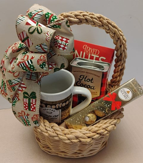 Gift basket with a coffee mug, hot cocoa mix, and chocolate bars on a neutral background