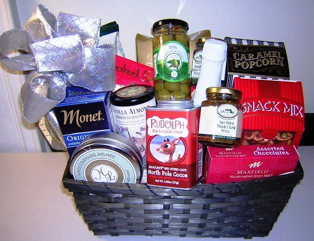 Hot cocoa selection gift basket for Christmas, Rudolph hot cocoa mix, assorted chocolates, tin of gourmet tea, pretzel, nuts and gourmet snacks.