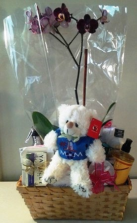 Body and bath gift basket with body wash, body balm, body lotion, and a personalized teddy bear for the recipient. 