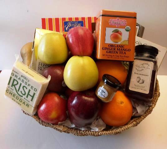 A basket packed with fresh fruit, cheddar cheese, fruit jam, orange ginger mango tea, and a coffee cake for Boston delivery