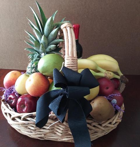 A basket packed with ripe mangoes- pineapple, boss pears, and ripe bananas. At KJ Paula in Boston for a condolences delivery.