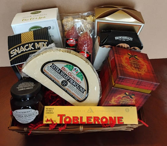 Assorted gift items including a block of cheese, chocolate, and other packaged goods in a basket.