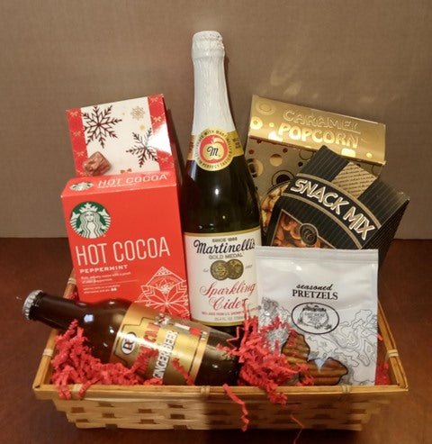 Wicker gift basket with hot cocoa, sparkling cider, caramel popcorn, snack mix and chocolate-covered pretzels