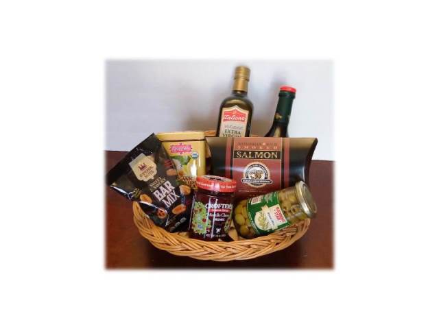 Wicker basket with assorted food items including salmon, chips, and drinks on a white background