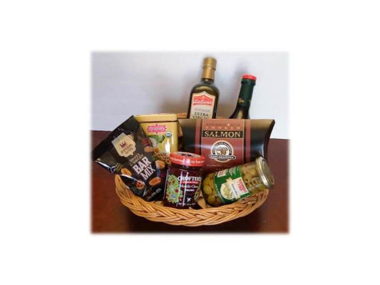 Wicker basket with assorted food items including salmon, chips, and drinks on a white background