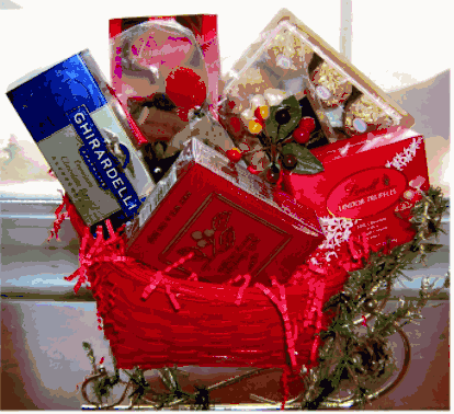 Red wicker Christmas gift basket with boxed chocolates, red tissue paper and festive greenery