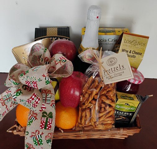 Wicker gift basket with apples, oranges, pretzels, Irish cheddar and biscuits, finished with a gift-patterned bow