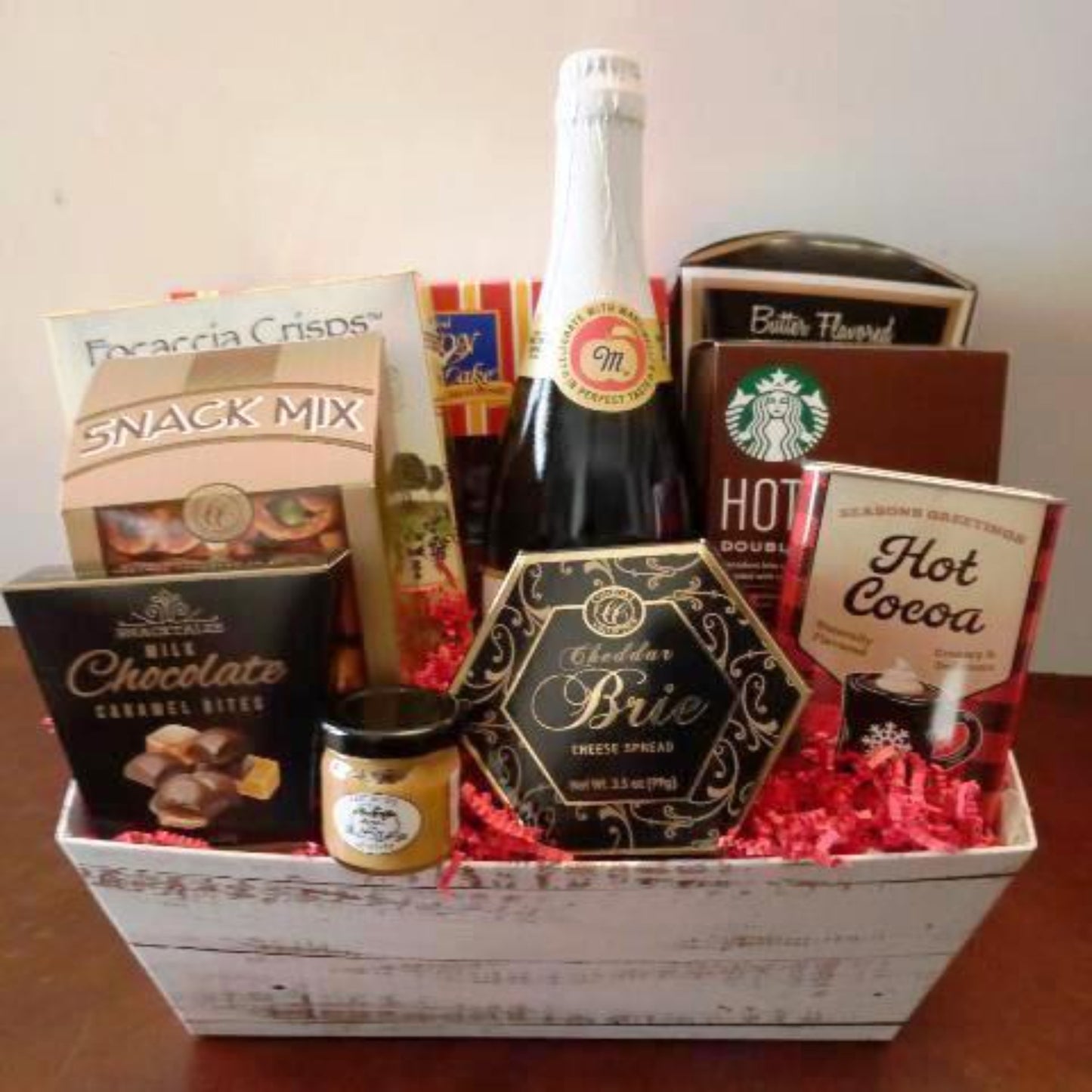  This gift basket is packed with Christmas hot cocoa mix, hot chocolate mix, box of snack mix, and cheese