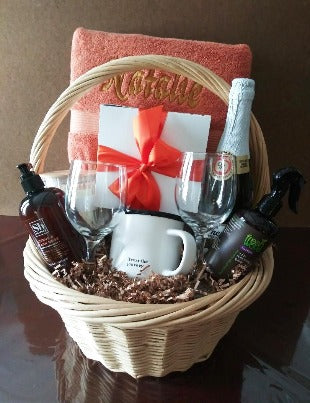 A Gift Basket filled with embroidery towels and personalized gift items. A mug and bath and body products. At KJ Paula Gift in Boston, MA.