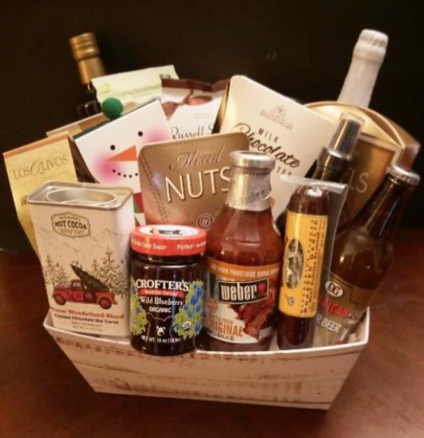 This Christmas 2024 gift basket is complete with olive cooking oli, grilling sauce, pretzels, nuts and Christmas hot chocolate mix
