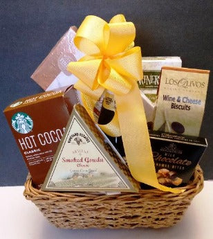 A wicker basket packed with chocolate, hot cocoa mix, gourmet cookies, and crackers from Boston 02199 to Wellesley 02481